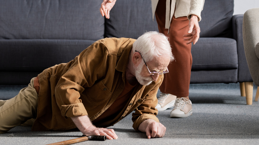 Elderly man with cane has fallen to the floor.